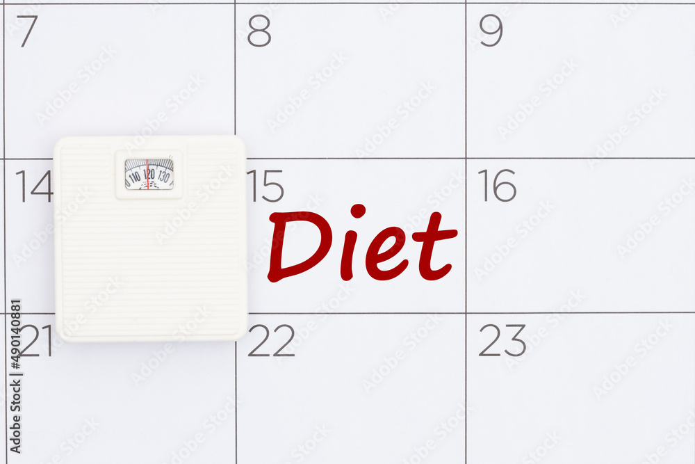 Starting diet date concept on a calendar with a weight scale Starting diet date concept on a calendar with a weight scale