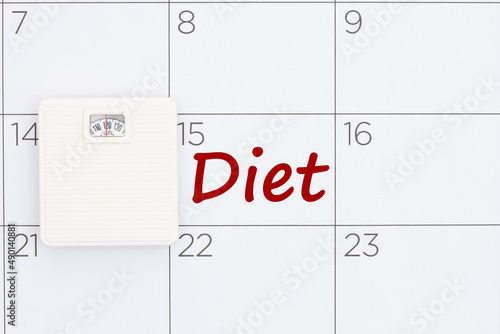 Starting diet date concept on a calendar with a weight scale