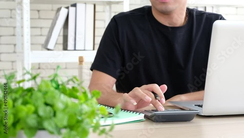 Businessman working on desk office financial graph with using a calculator to calculate the accounting investment and finance concept.