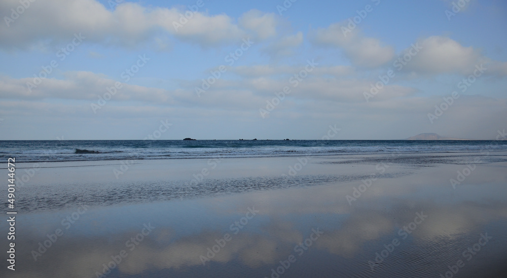Seashore with the sky reflected on the water at low tide, Caleta de Famara, Canary Islands