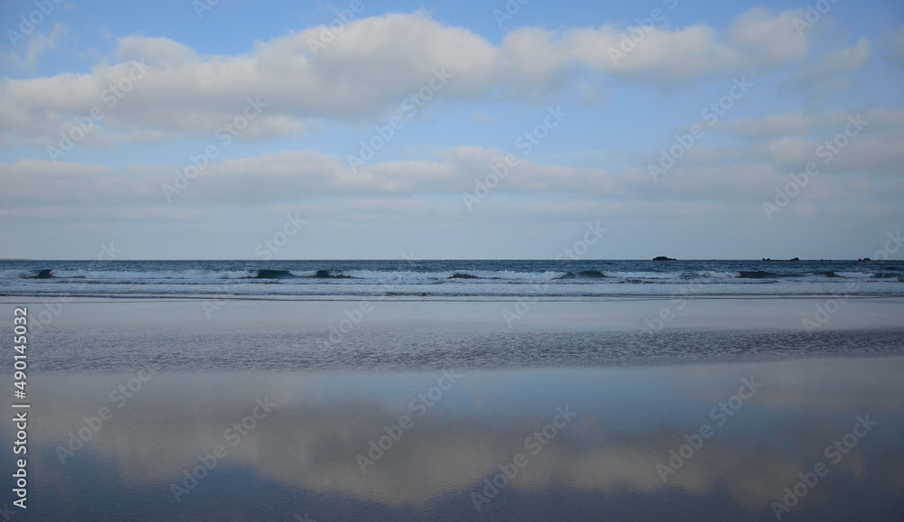 Reflections of the sky on the sea shore at low tide, Famara beach, Lanzarote, Canary Islands