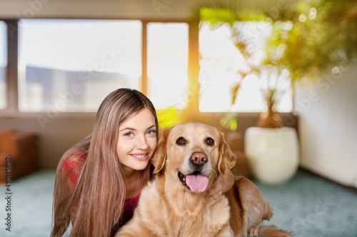 Portrait of cheerful young woman in casual outfit carrying her sweet fluffy dog