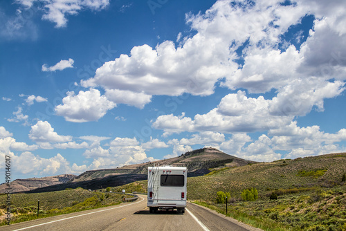 Fotografija White camper driving on two lane highway with low southern Colorado mountains an