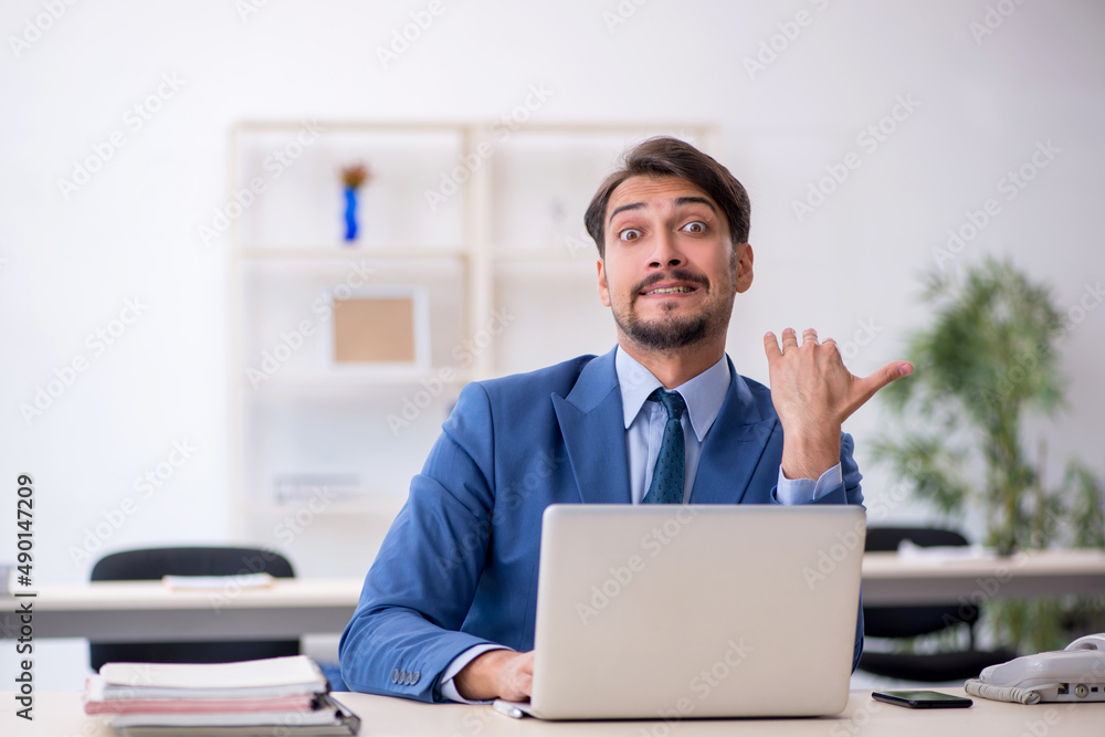 Young male employee working in the office Young male employee working in the office