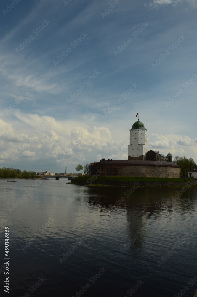 medieval white castle in russia on the water against the background of clouds in cloudy weather free space