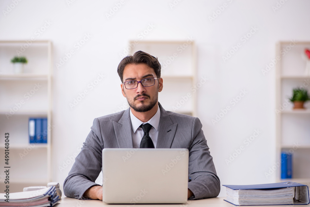 Young male employee working in the office Young male employee working in the office