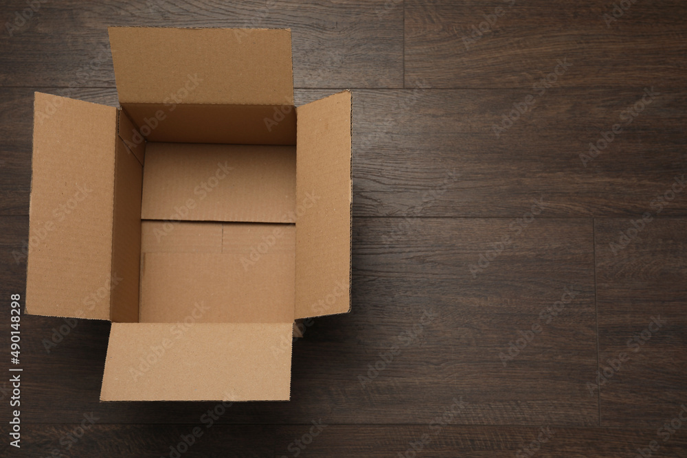 Empty open cardboard box on wooden table, top view. Space for text Empty open cardboard box on wooden table, top view. Space for text