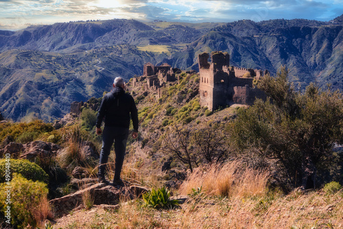 Man looking at an old abandoned village in the mountains.