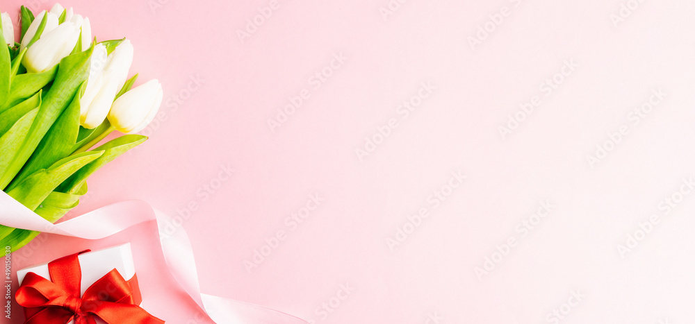 Mothers day gift. Spring white tulip flower, gift with red ribbon on flat lay pink background. Valentines, birthday, women or wedding day concept. Mothers day gift. Spring white tulip flower, gift with red ribbon on flat lay pink background. Valentines, birthday, women or wedding day concept.