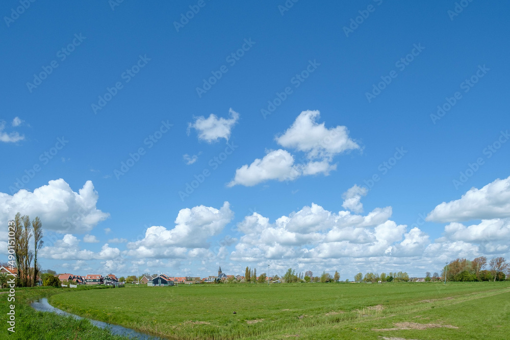 Fototapeta premium Het voormalige eiland Marken in het IJsselmeer, kenmerkt zich door kleurrijke huisjes die dichtopeen staan op de werven en ademt de sfeer van vroeger uit.