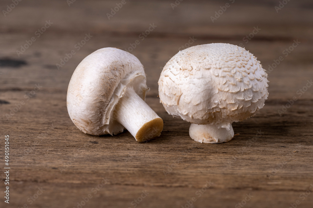 Fresh raw organic champignons heap on a wooden table. Fresh raw organic champignons heap on a wooden table.