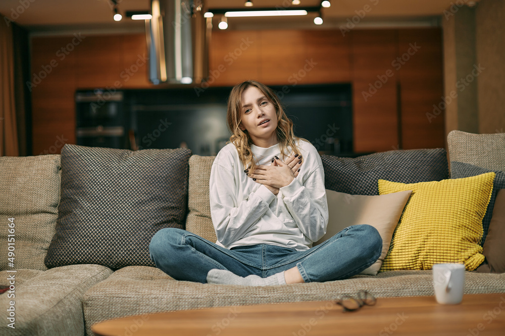 Touched young woman watching soap opera, feel happy from tender moment of romantic movie, sitting on couch at home Touched young woman watching soap opera, feel happy from tender moment of romantic movie, sitting on couch at home