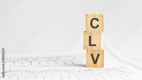 CLV - letters on wooden cubes. concept on cubes and diagrams on a gray background. business as usual concept imag.