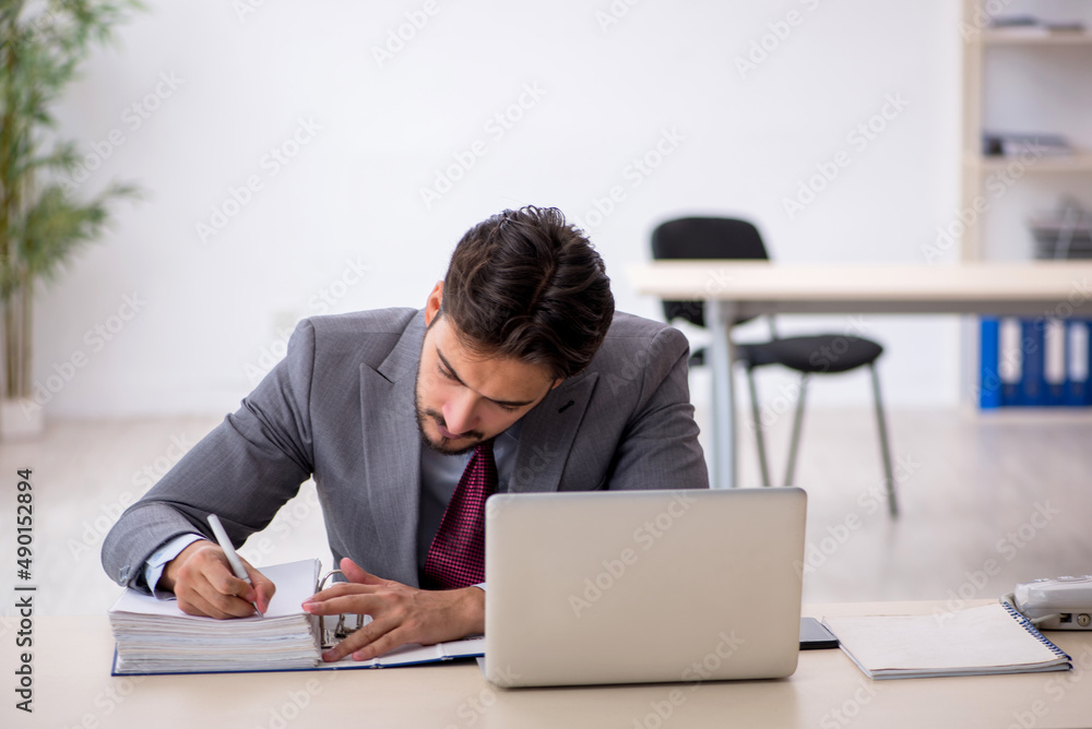 Young male employee working in the office Young male employee working in the office