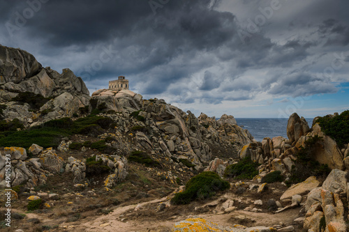 l'ancien semaphore de Capo Testa en Sardaigne qui servait de phare au milieu des roches de granit sous un ciel d'orage