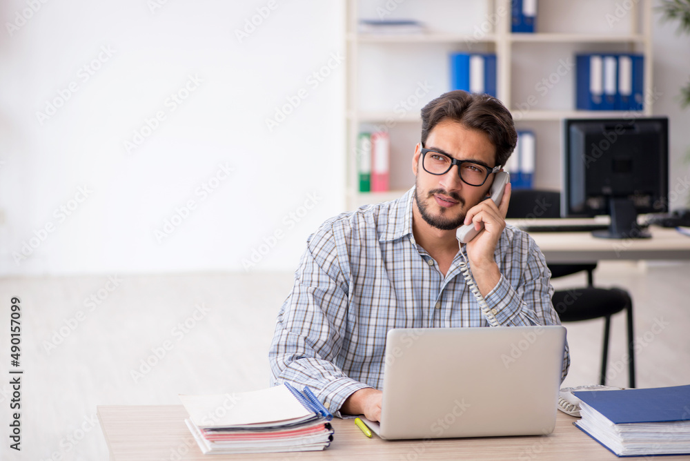 Young male employee sitting in the office Young male employee sitting in the office