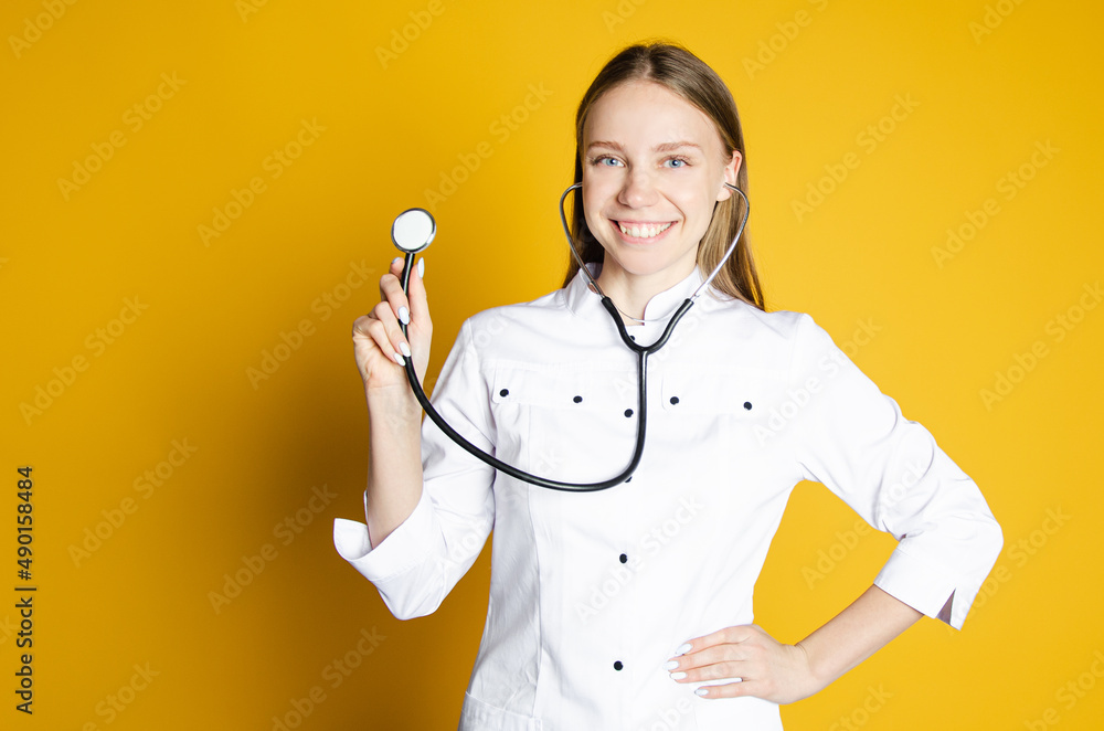 girl doctor on yellow background points to empty place. concept medical service girl doctor on yellow background points to empty place. concept medical service