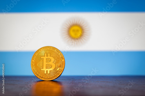 Bitcoin physical golden coin with Argentina flag in the background photo