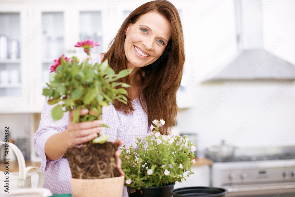 See how easy this is. Portrait of a beautiful woman potting some plants for summer.