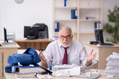 Old male employee unhappy with excessive work in the office