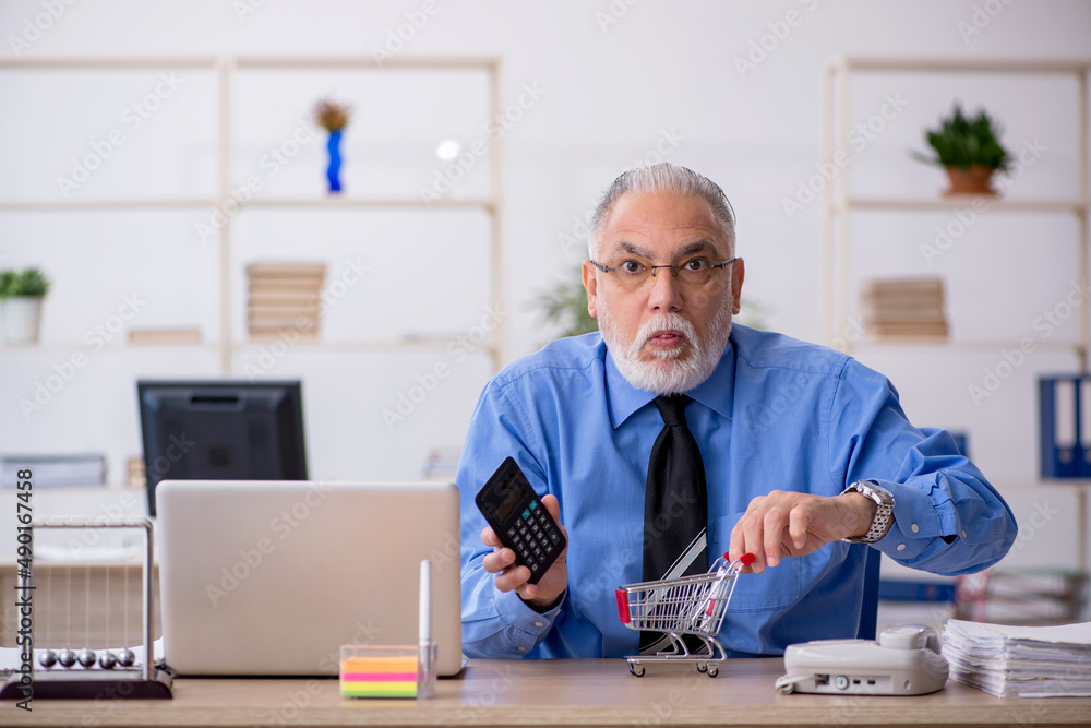 Old male bookkeeper working in the office Old male bookkeeper working in the office
