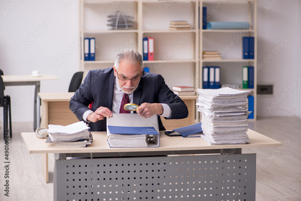 Aged male employee and too much work at workplace Aged male employee and too much work at workplace