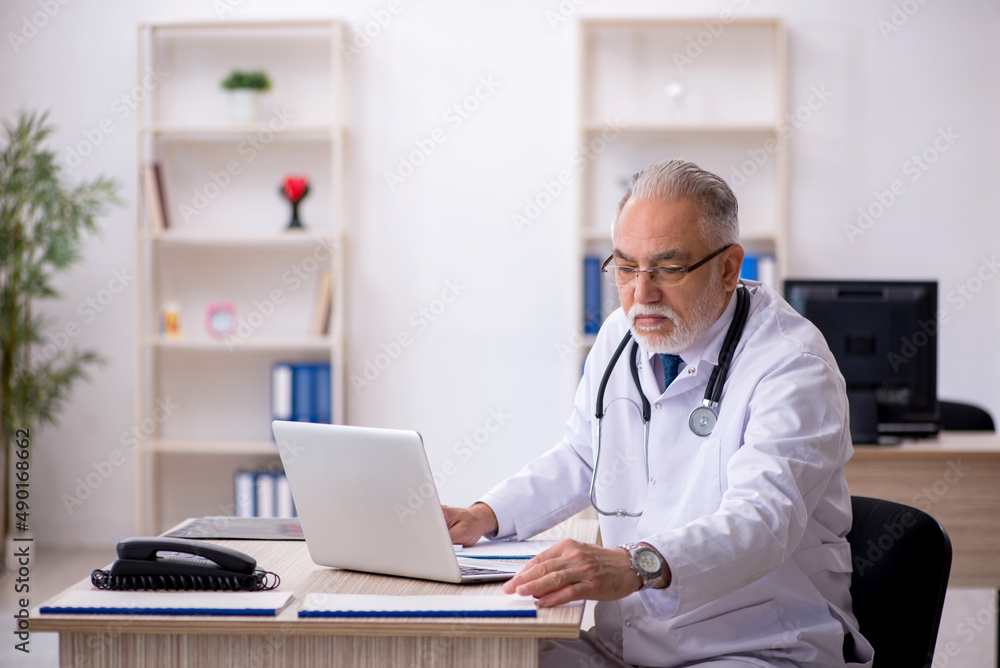 Old male doctor in telemedicine concept Old male doctor in telemedicine concept
