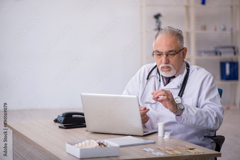 Old male doctor working at the hospital Old male doctor working at the hospital