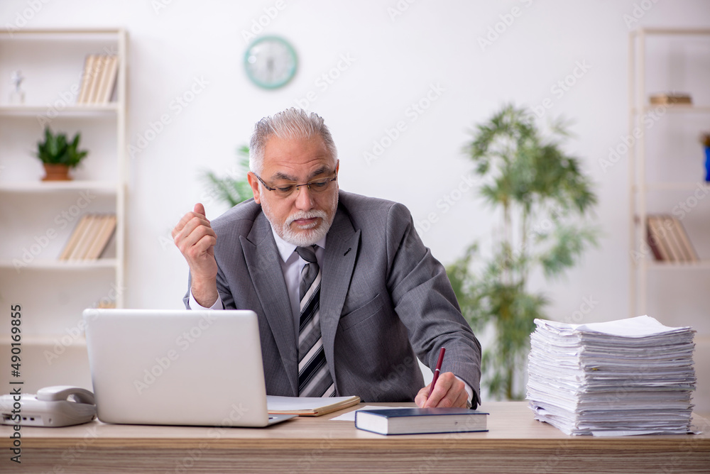 Old male employee and too much work in the office Old male employee and too much work in the office