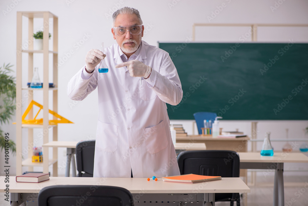 Old male chemist teacher in the classroom Old male chemist teacher in the classroom