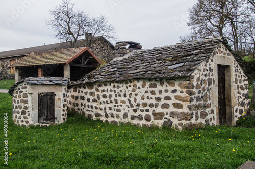 Rustic stone building on green grass in Saint Julien Chapteuil, Auvergne, France photo