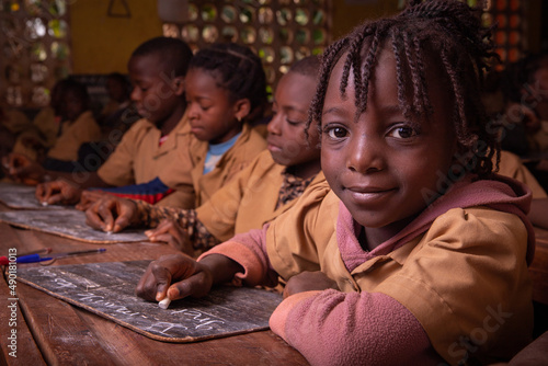 Students in a school in africa take the lesson and write notes on a blackboard with chalk. Children at school in Africa