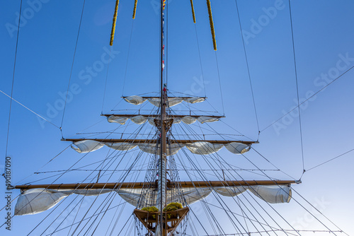 Fototapeta Low angle shot of the mast with sails of a tall ship against a clear sky
