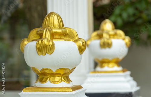 Closeup shot of white and golden punkalasa (filled pot) against a blurred background photo