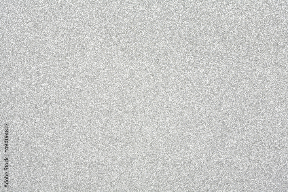 Horizontal silver glitter close up, card stock texture background.