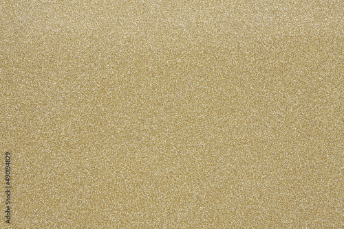 Horizontal gold glitter close up, card stock texture background. 