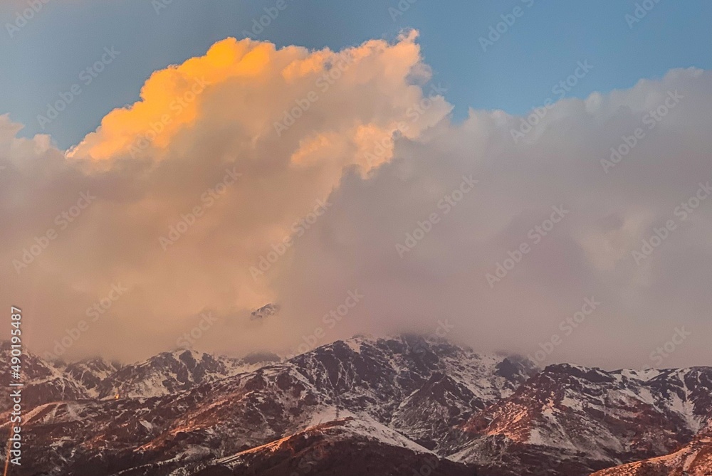 sunset in the snowy cloudy mountains