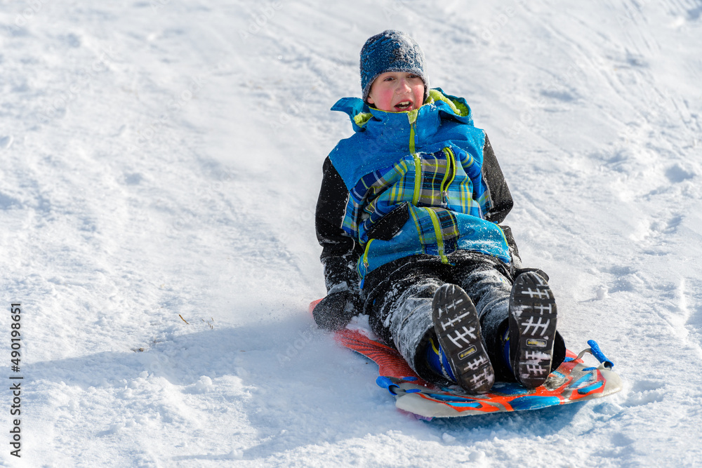 Boy Sledding Down Hill on Snow