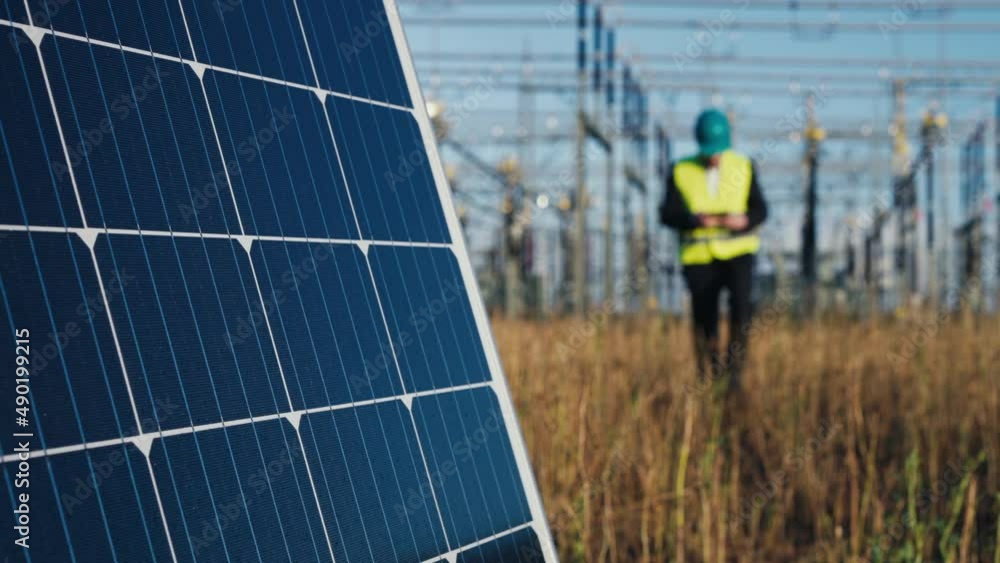 Close up of Solar photovoltaic panel with electric engineer and substation in background shot in 4k super slow motion Close up of Solar photovoltaic panel with electric engineer and substation in background shot in 4k super slow motion