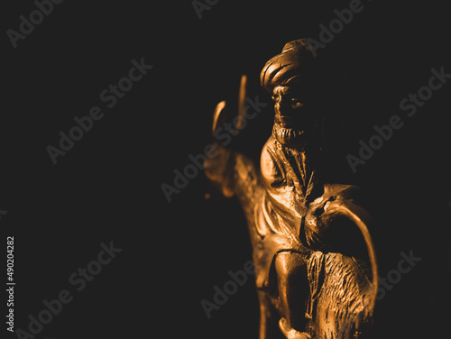 Closeup of a golden sculpture of Nasreddin Hodja riding a donkey backwards Fototapete