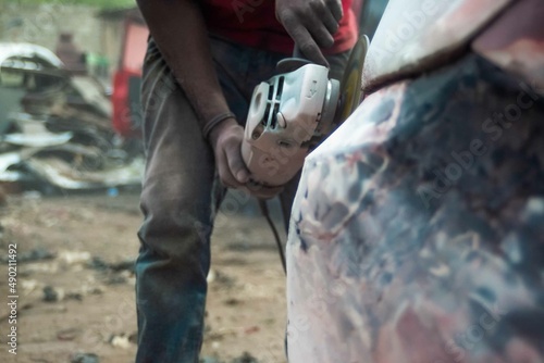 Grinding Parts of a Car, Sanding a car part, Welding a Car in Africa, 2 African men working on a car, African American auto mechanic at work, African American working with electrodes