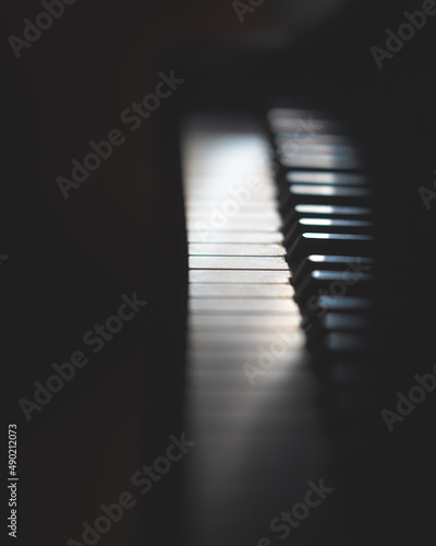 Vertical closeup shot of the piano keyboards in the dark photo