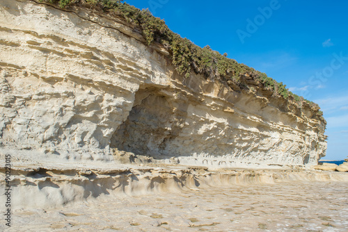 Limestone cliff, notch, wave-cut platform along the coast of Delimara, Malta showing coastal erosion photo