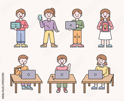 Cute students are sitting in the classroom and teaching online lessons on laptops. flat design style vector illustration.