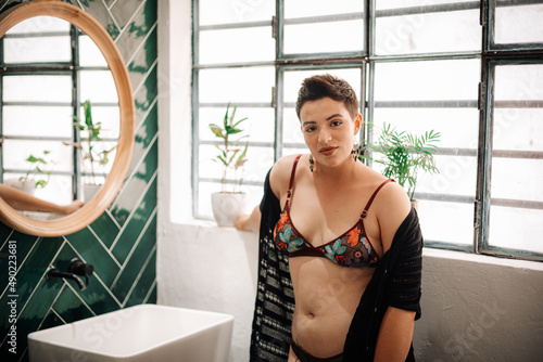 Young Middle Eastern short-haired woman looking at the camera in the bathroom.