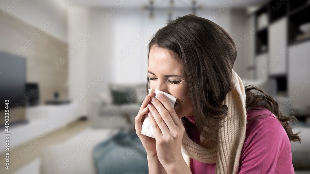 Unhappy sad young female suffering from fever and flu, blowing nose in napkin Unhappy sad young female suffering from fever and flu, blowing nose in napkin