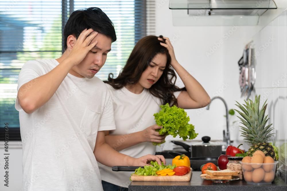 tired couple cooking and preparing vegetables in kitchen at home tired couple cooking and preparing vegetables in kitchen at home