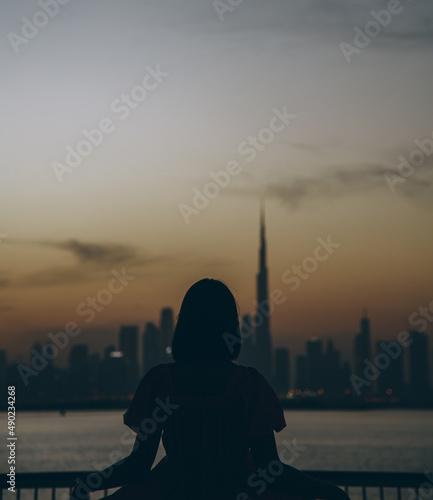 Foto Young woman looking a Dubai creek harbor in Burj khalifa