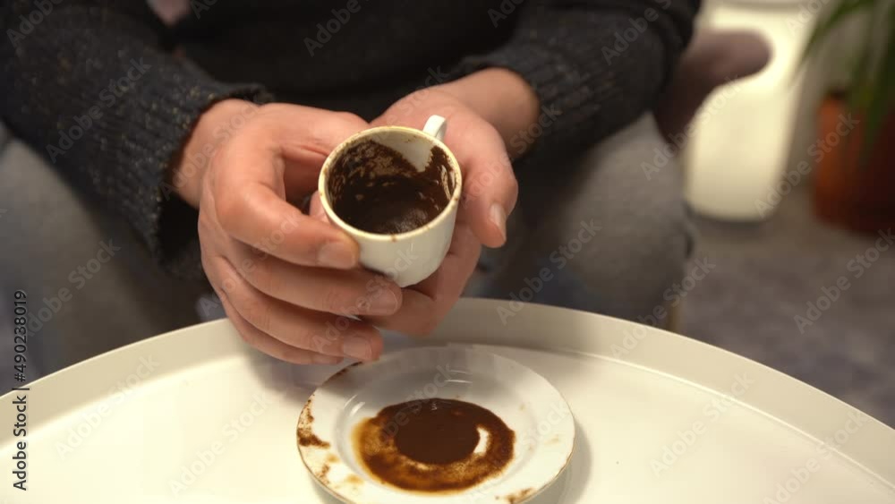 Fortune teller is telling fortunes. He looks at the coffee fortune of