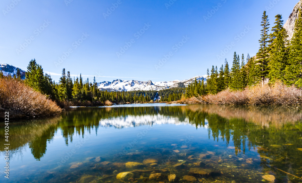 Snow-capped mountains reflected on pond in Mammoth Lakes, California.